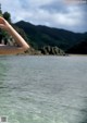 A woman standing in the water with her arms outstretched.