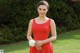 A woman in a red dress holding a bouquet of flowers.