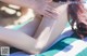 A woman laying on a beach towel with her legs crossed.