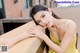 A woman in a yellow dress leaning on a railing.