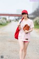 A woman in a baseball uniform holding a baseball bat.