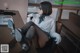 A woman in a white shirt and black stockings sitting at a desk.