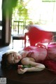 A woman laying on a table with a rose in her hand.