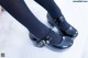 A close up of a person wearing black tights and black shoes.