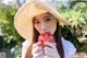 A woman in a straw hat holding an apple.