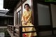 A woman in a yellow kimono sitting on a balcony.