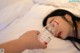 A woman laying in bed with a bottle of water.