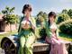 A couple of women sitting on top of a wooden bench.