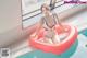 A woman in a bathing suit sitting on an inflatable ring in a pool.